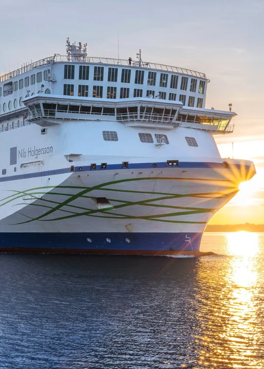 Ein großes Kreuzfahrtschiff in Weiß und Blau liegt im Wasser, beworben für eine Minikreuzfahrt mit der TT-Line nach Schweden.