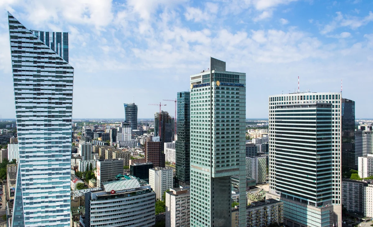 Blick auf die Skyline von Warschau aus der Vogelperspektive, mit modernen Gebäuden und einer klaren blauen Himmel.