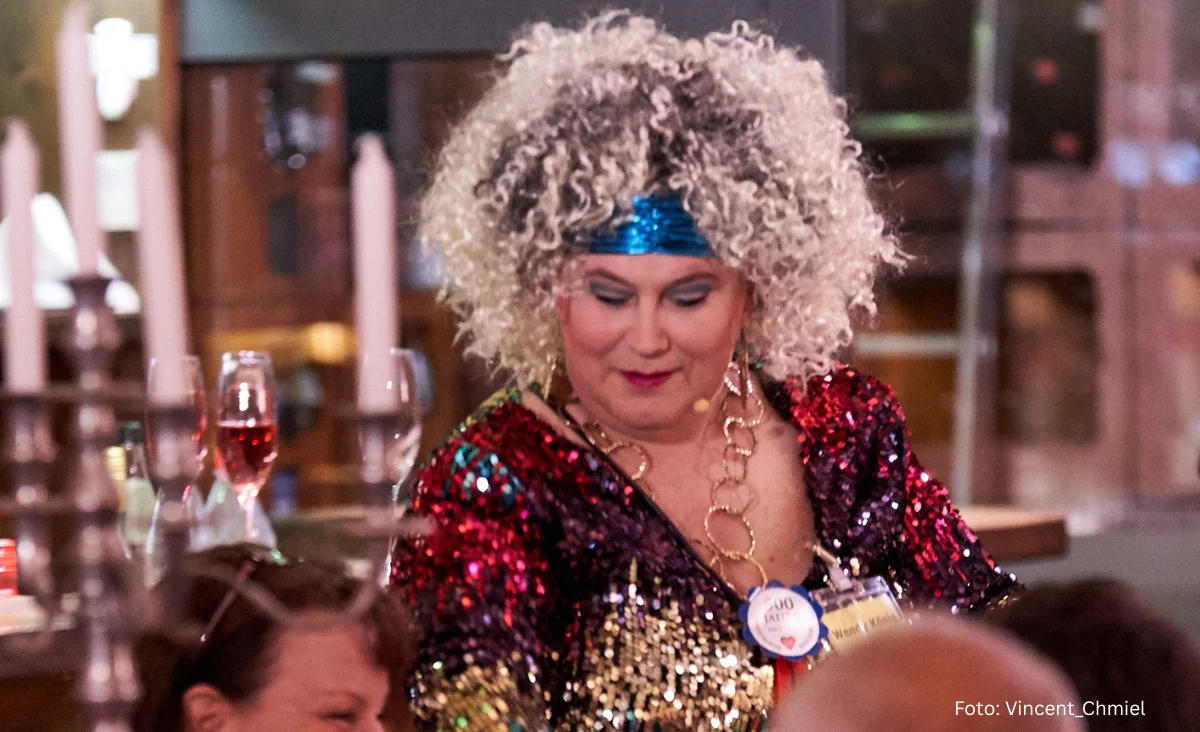 ine Frau in einem glitzernden Kleid bei einer eleganten Dinnerparty.