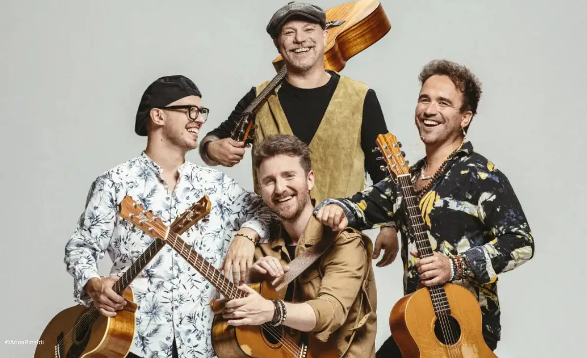 Vier Musiker mit Gitarren im Gruppenporträt