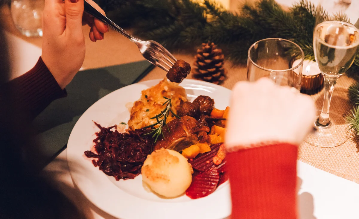 Festliches Weihnachtsessen mit traditionellen Gerichten wie Knödel, Rotkohl und Fleisch beim All Inclusive Weihnachtsmarkt Schöneweide