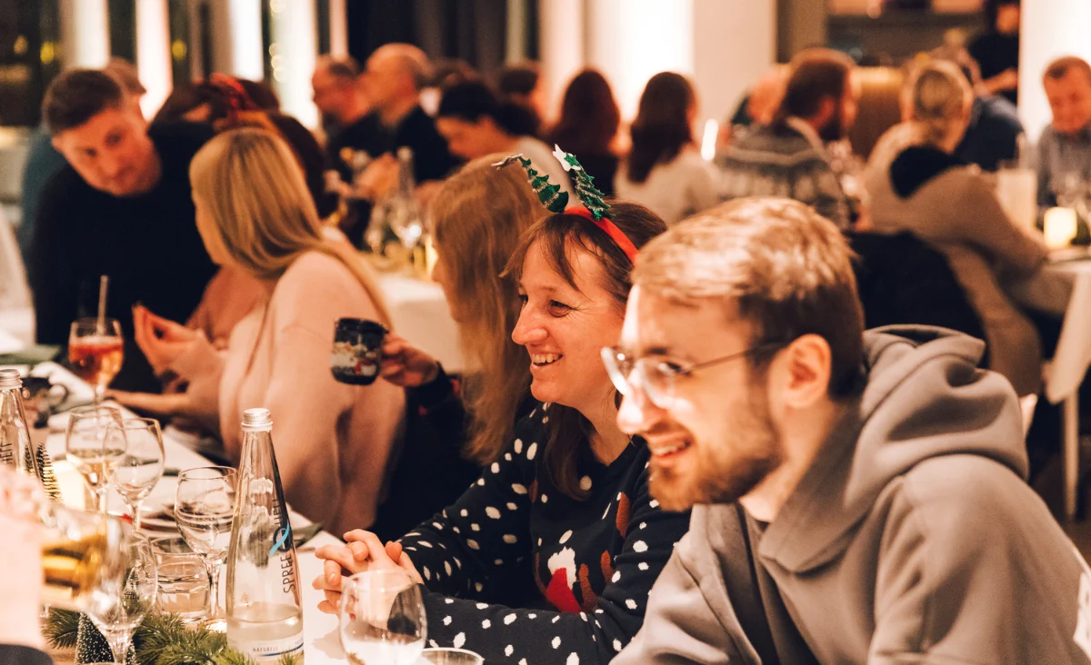 Gäste beim fröhlichen Beisammensein und festlichen Dinner auf dem All Inclusive Weihnachtsmarkt Schöneweide